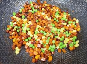 下入豌豆和玉米粒翻炒均匀。
