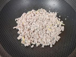 炒锅内倒适量的菜籽油烧热，下入姜丝和肉馅翻炒至变色。