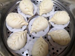 蒸锅里放水，包子生胚垫上油纸放在篦子上，二次发酵10分钟左右。