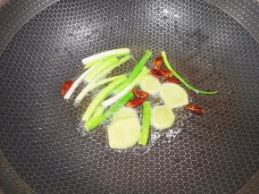 炒锅内倒适量的菜籽油烧热，下入小葱、姜片和干红辣椒炒香。