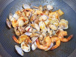 下入花甲翻炒均匀。