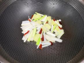 炒锅内倒适量的菜籽油烧热，下入葱姜和干红辣椒炒香。