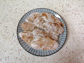 腌好的鸡翅裹上一层干粉。