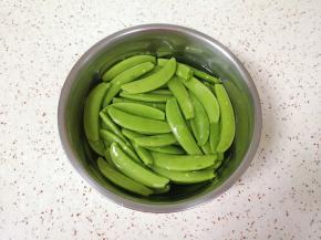 甜豆抽丝，用淡盐水浸泡10分钟左右清洗干净。