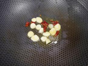 锅里继续倒油烧热，下入蒜片和干红辣椒炒香。