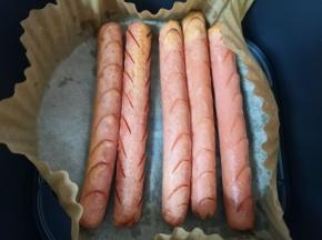 5分钟以后抽出空气炸锅炸篮，将火腿肠翻面。