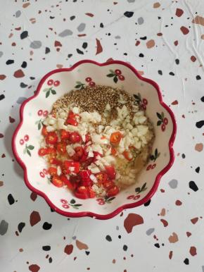 碗中放入蒜末，一勺盐，小米辣，熟白芝麻，再倒入适量的热油，激发出蒜香味儿！