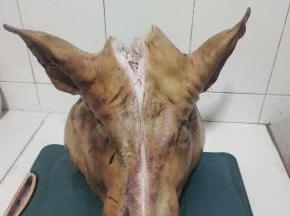 再在猪头两边都划开，要不然卤的时候，肉太厚，不容易熟！(本来想对半剁开，剁了半天也没剁动，只好去借了一个大钢筋锅，卤整个的！)