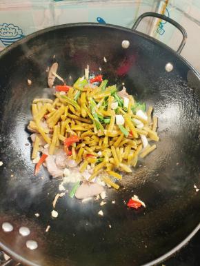 放入酸豇豆，酸辣椒和蒜苗翻炒均匀！