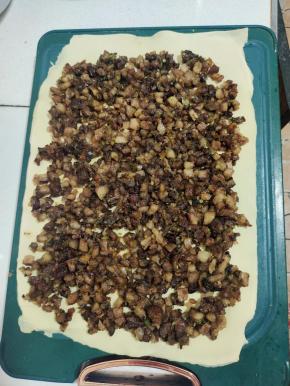 炒好的猪头肉放在千张上。用铲子铺平！