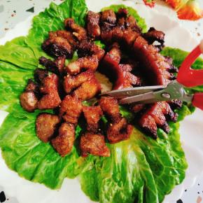 把烤好的脆皮五花肉摆放在盘子里，用干净的厨房剪刀剪成小块儿！