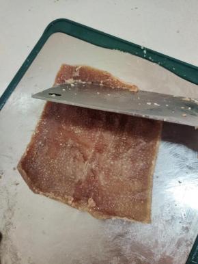 不用过凉水，趁热把猪皮里面多余的油脂刮干净！