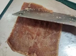 不用过凉水，趁热把猪皮里面多余的油脂刮干净！