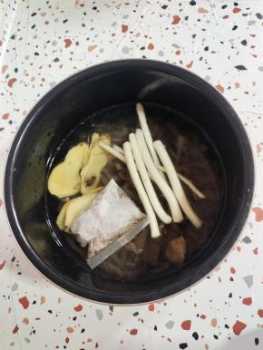 肉皮和水的比例是1:2的比例加水！（我这里是切好的猪皮1碗半，我加了3碗水！）再放入姜片，葱段和一个卤料包！