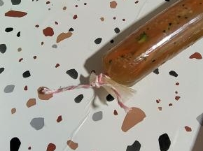 不要灌的太满，在尾部用棉绳打一个活结，一会儿分节扎的时候，有可能还需要把它打开排气！