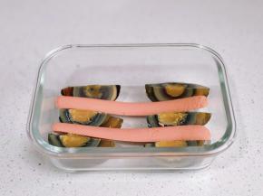 六瓣皮蛋摆入器具中，放上火腿肠。