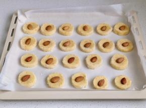 摆入烤盘中，每块中间按一颗杏仁。