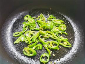 锅中热油，放入青椒炒熟。