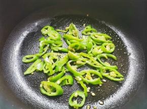 锅中热油，放入青椒炒熟。