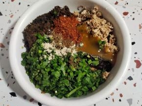 碗中放入剁碎的猪油渣，泡发好的干酸菜，韭菜（也可以换成葱花），1勺胡椒粉，1勺花椒粉，1大勺生抽，1勺蚝油，1勺太太乐鸡汁鲜，1勺辣椒面！