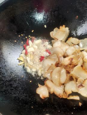 把多余的油倒出来，留少许油，放入生姜，花椒，蒜瓣，干辣椒爆香！