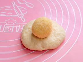 取一块面团包上椰蓉馅收口捏紧。