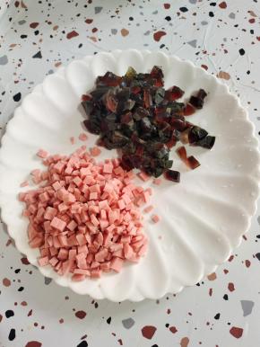 煮熟的皮蛋放在冷水中浸泡一下，剥壳切成小丁，火腿肠切成小丁备用！