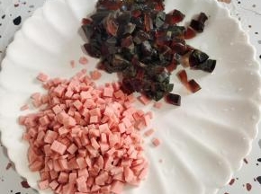 煮熟的皮蛋放在冷水中浸泡一下，剥壳切成小丁，火腿肠切成小丁备用！