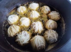 锅中下半锅油，烧至五成热，轻轻放入包好的丸子小火慢炸，边炸边轻轻晃动锅，炸至金黄酥脆捞出，再复炸一次即可。