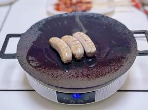 烤盘中喷油，放入烤肠。