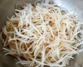 焯好水的银针立即放入冷水中过凉，再沥干水份备用。