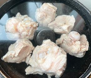 另起锅添加适量清水，放入料酒、调味盒和猪骨棒大火炖起来。