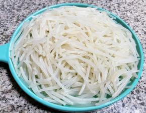 焯好水的银针立即放入冷水中过凉，再沥干水份装入盘中备用。