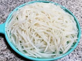 焯好水的银针立即放入冷水中过凉，再沥干水份装入盘中备用。