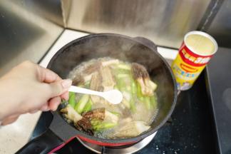 加入开水、勺入鸡粉翻炒均匀