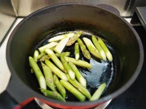 热油锅后放入洗净去老皮斜刀切段的芦笋大火翻炒2分钟