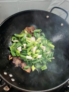 放入蒜苗翻炒均匀！