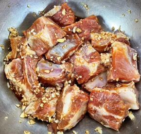 蒜粒轻轻按摩至和排骨均匀的融合在一起，盖上保鲜膜放入冰箱冷藏六个小时左右