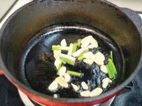 热锅后，锅里倒入20毫升植物油，放入姜片、蒜片和小葱段一起煸炒出香味