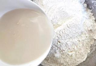 适量面粉放入容器中，用温水冲调酵母粉拌匀，淋在面粉中开始和面。