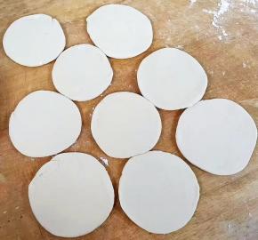 压扁后的面团擀成厚薄均匀的小饼，不要太薄。醒发十五分钟。