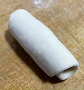 从一侧卷起，竖起来从下往上压扁。