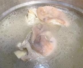 另起锅猪肘棒和调味盒放入清水中，在放入糖、料酒大火炖起来。