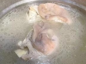 另起锅猪肘棒和调味盒放入清水中，在放入糖、料酒大火炖起来。