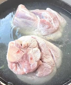 锅中烧开水倒入料酒，放入猪肘棒焯水断生，去除多余的油脂和杂质，再放入冷水中过凉多冲洗几遍洗净。