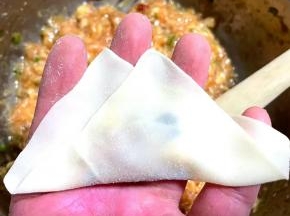 云吞皮对折，两端的云吞皮向中间聚拢。