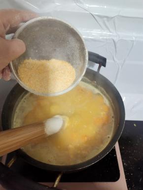 放入一碗苞谷碜！苞谷碜要少量多次的均匀的投放进锅里，边放边搅拌，以免结成疙瘩！