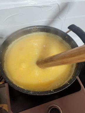 苞谷碜全部搅拌进锅里后，调小火，继续边搅拌边煮！