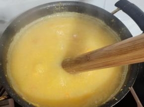 苞谷碜全部搅拌进锅里后，调小火，继续边搅拌边煮！