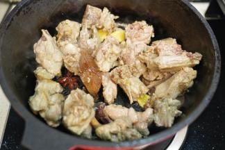 放入去血沫的鸭腿、香叶、桂皮、八角、料酒一起翻炒至鸭腿表面焦黄